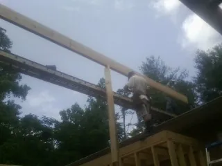Carpenter setting a ridge beam over a new addition frame — Ice Dam Removal by Roofing Brothers in Shasta Lake