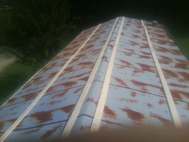 Rusted metal roof panels with new wood purlins before replacement — Storm Damage Roof Repair in Shasta Lake by Roofing Brothers